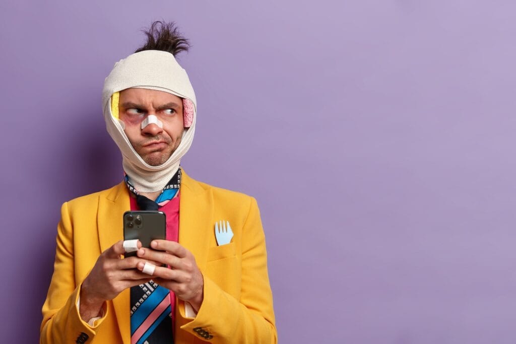Uomo con bendaggi dopo un incidente, usa lo smartphone - assicurazione e protezione Fixxy