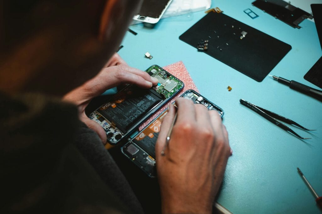 Tecnico Fixxy ripara un smartphone smontato sul banco di lavoro